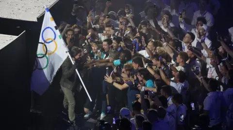 EPA Tom Cruise is mobbed by athletes in the Stade de France