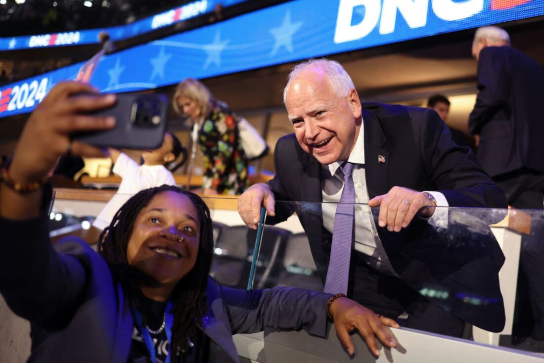 Minnesota governor and 2024 Democratic vice presidential nominee Tim Walz poses for pictures with an attendee on the first day of the Democratic National Convention at the United Center in Chicago on Monday. Walz is addressing the convention on Wednesday to accept the party's nomination.