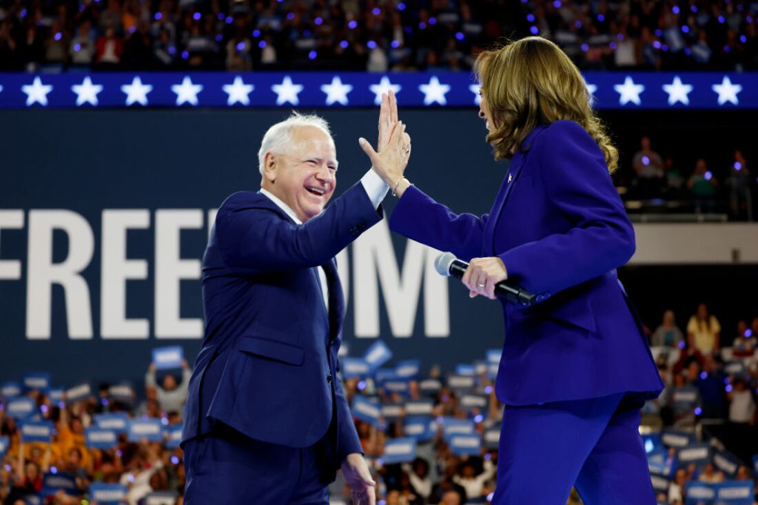 Democratic vice presidential candidate Minnesota Gov. Tim Walz high-fives presidential nominee Kamala Harris at a campaign rally at the Fiserv Forum on Tuesday in Milwaukee.