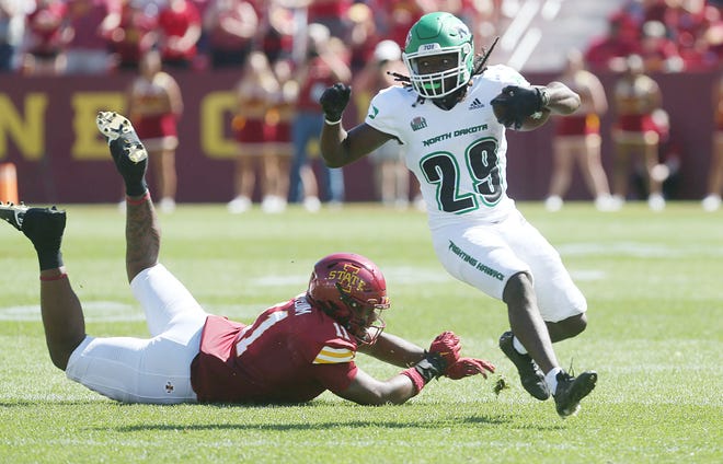 North Dakota Fighting Hawks running back Isaiah Smith (29) breaks a tackle from Iowa State Cyclones defensive end Tyler Onyedim (11) and runs for a first down during the first quarter in the season opening game at Jack Trice Stadium on Aug. 31, 2024,  in Ames, Iowa