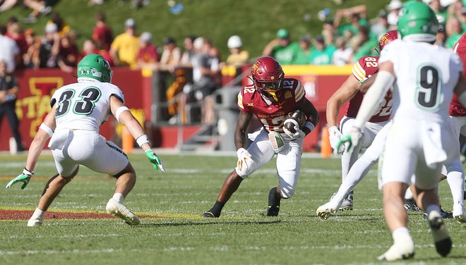 Iowa State Cyclones running back Jaylon Jackson (12) runs with the ball between North Dakota Fighting Hawks quarterback Jett Sutton (33) and North Dakota Fighting Hawks defensive back Tyler Erkman (9) during the third quarter in the season opening game at Jack Trice Stadium on Aug. 31, 2024,  in Ames, Iowa