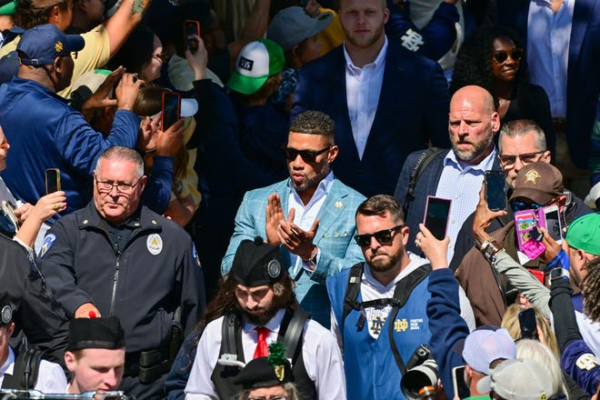 Sep 7, 2024; South Bend, Indiana, USA; Notre Dame Fighting Irish head coach Marcus Freeman enters the stadium alongside players for the game against the Northern Illinois Huskies at Notre Dame Stadium. Mandatory Credit: Matt Cashore-Imagn Images