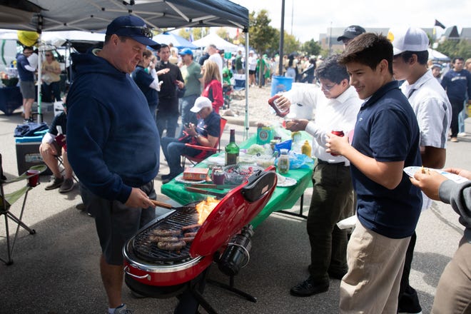 The Rev. Christopher Gronotte, left, grills at a tailgate before a NCAA college football game between Notre Dame and Northern Illinois at Notre Dame Stadium on Saturday, Sept. 7, 2024, in South Bend.