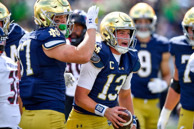 Sep 7, 2024; South Bend, Indiana, USA; Notre Dame Fighting Irish quarterback Riley Leonard (13) celebrates after scoring a touchdown in the first quarter against the Northern Illinois Huskies at Notre Dame Stadium. Mandatory Credit: Matt Cashore-Imagn Images