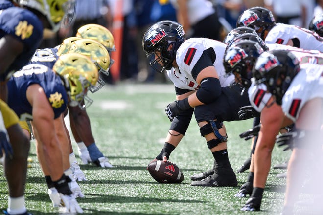 Sep 7, 2024; South Bend, Indiana, USA; Northern Illinois Huskies center Logan Zschernitz (65) prepares to snap the ball in the first quarter against the Notre Dame Fighting Irish at Notre Dame Stadium. Mandatory Credit: Matt Cashore-Imagn Images