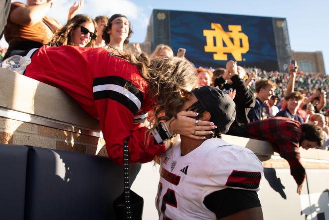 Northern Illinois linebacker Jaden Dolphin kisses his girlfriend Ruby Mendez Toomey after wining a NCAA college football game 16-14 against Notre Dame at Notre Dame Stadium on Saturday, Sept. 7, 2024, in South Bend.