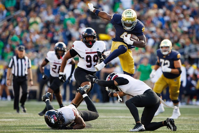 Notre Dame running back Jeremiyah Love (4) hurdles over Northern Illinois safety Nate Valcarcel on his way to score a touchdown during a NCAA college football game at Notre Dame Stadium on Saturday, Sept. 7, 2024, in South Bend.