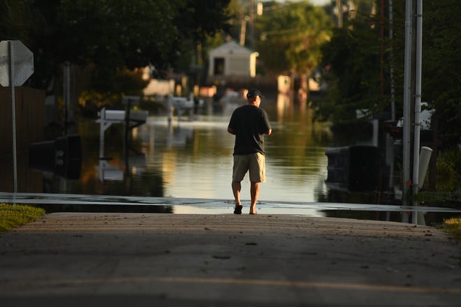 Residents and others look over the standing flood waters that remain around the Carolina Beach Lake area Tuesday Sept. 17, 2024 in Carolina Beach, N.C. KEN BLEVINS/STARNEWS