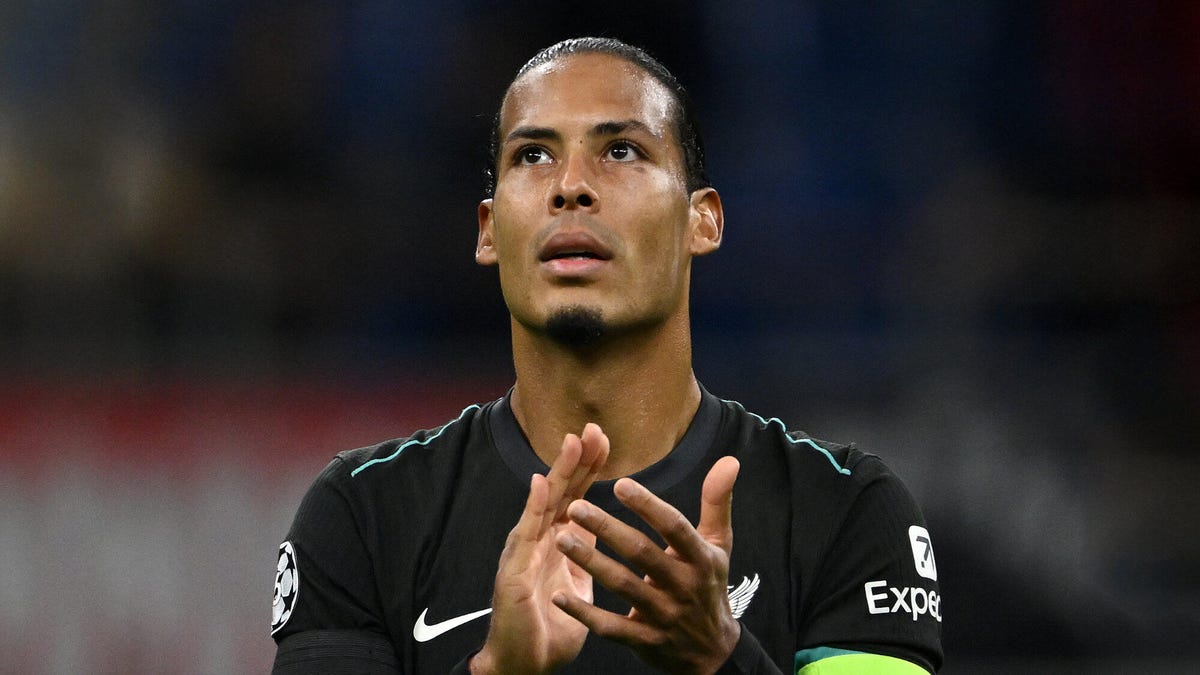 Liverpool player Virgil Van Dijk looking upwards applauding.