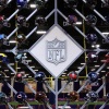 The NFL logo is surrounded by helmets of the 32 teams in the league. A new survey released Monday found that a third of former NFL players believe they have CTE, a degenerative brain disease linked to concussions.