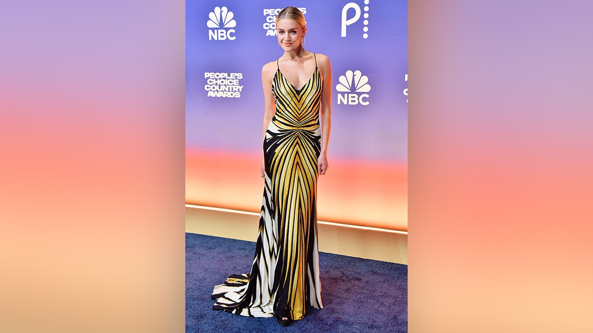 Kelsea Ballerini walked the red carpet at the 2024 People's Choice Country Awards in a yellow and white printed dress.