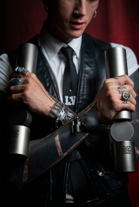 MGK, stands backstage holding his two People’s Choice awards at The Grand Ole Opry in Nashville , Tenn., Thursday, Sept. 26, 2024.