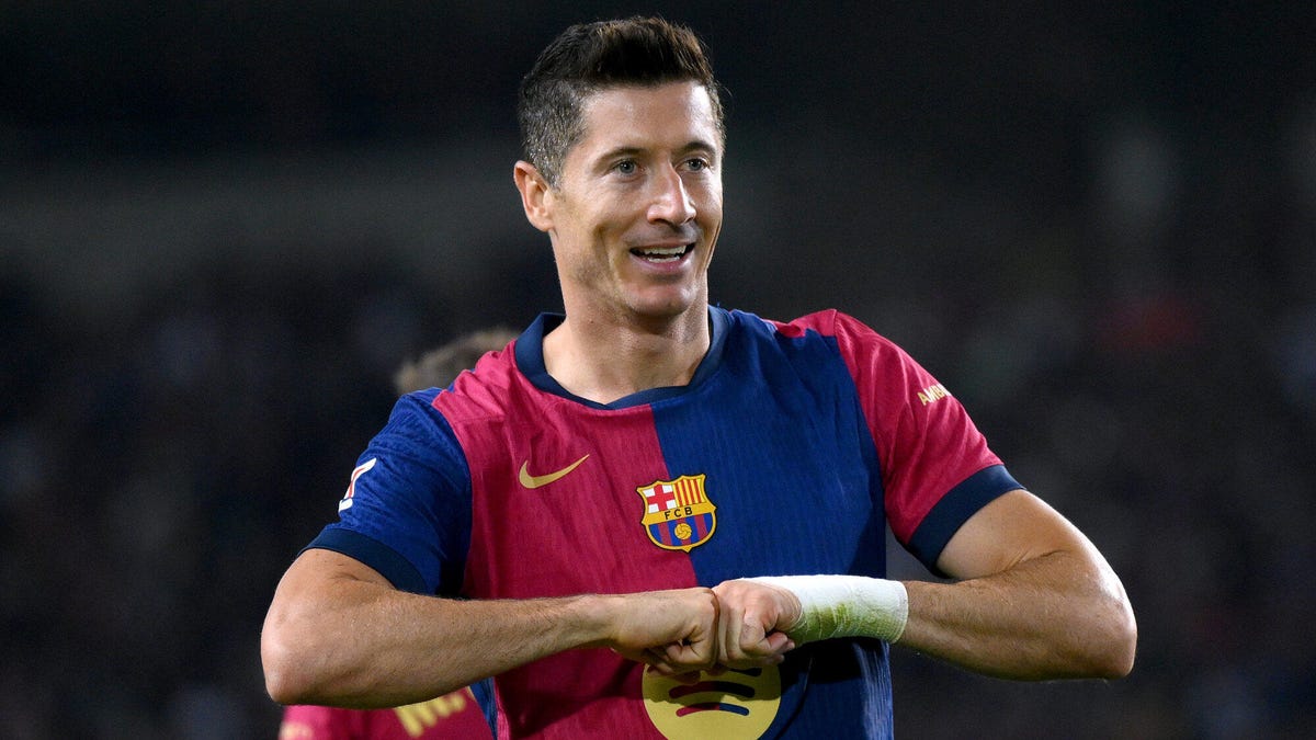 Barcelona forward Robert Lewandowski smiling, celebrating, making a clenched fist gesture with both hands.