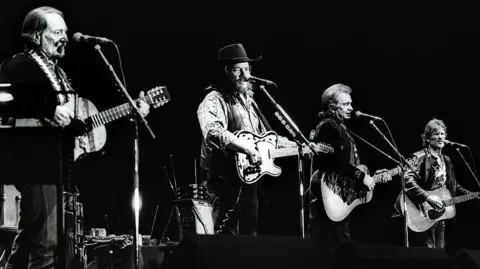 Getty Images The Highwaymen perform on stage in Ahoy, Rotterdam in 1992 in this black and white photo. Left to right is Willie Nelson, Waylon Jennings, Johnny Cash and Kris Kristofferson