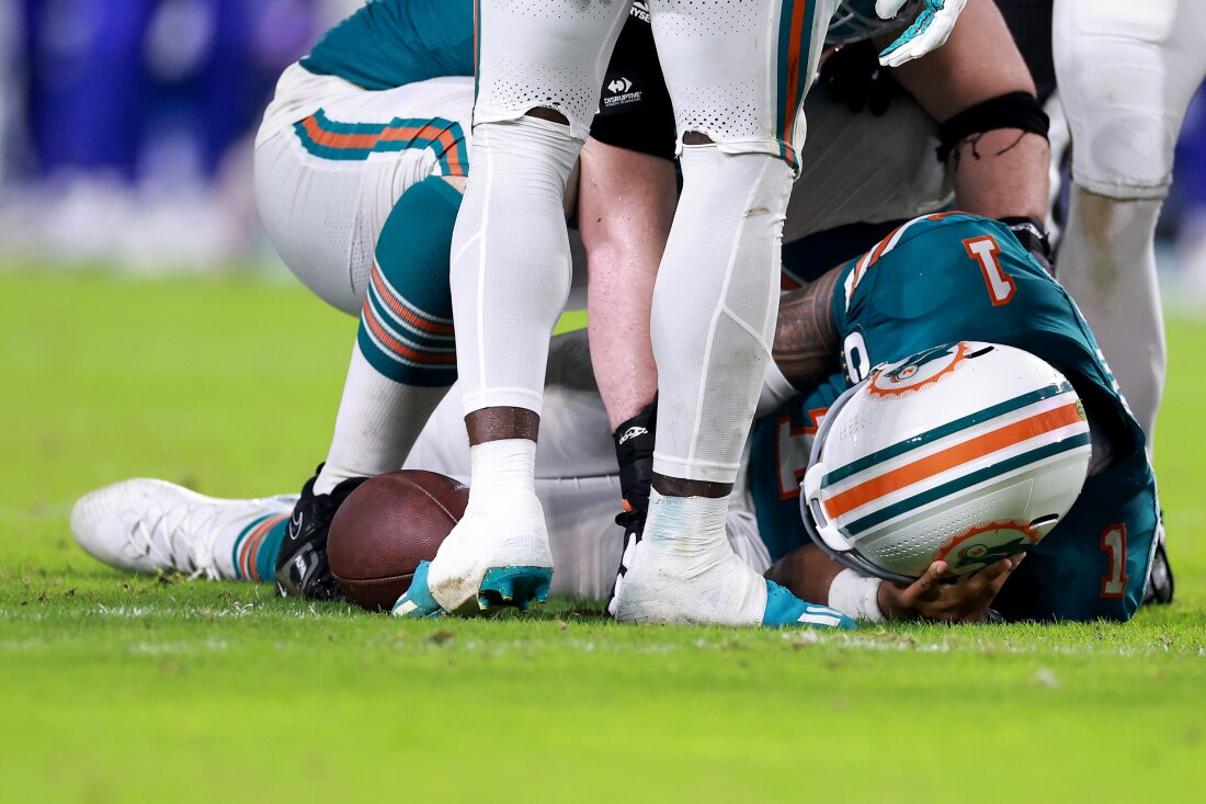 Miami Dolphins quarterback Tua Tagovailoa lays on the ground after colliding with a Bills defender during a Thursday night game.