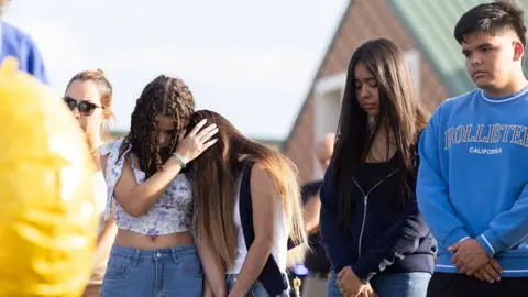 Getty Images Students and community members pray at a memorial outside of Apalachee High School on September 5, 2024 in Winder, Georgia.