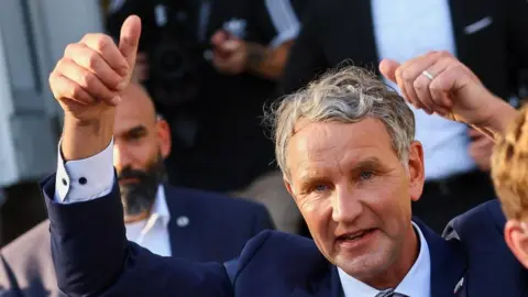 Reuters Top candidate of the far-right AfD (Alternative for Germany) party for regional elections in Thuringia Björn Höcke (L) casts his ballot at a polling station in Bornhagen