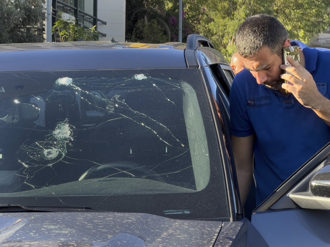 A Lebanese police officer inspects a car damaged by an exploding pager in Beirut on Tuesday. Hundreds of pagers belonging to Hezbollah members exploded simultaneously. The group blamed Israel.