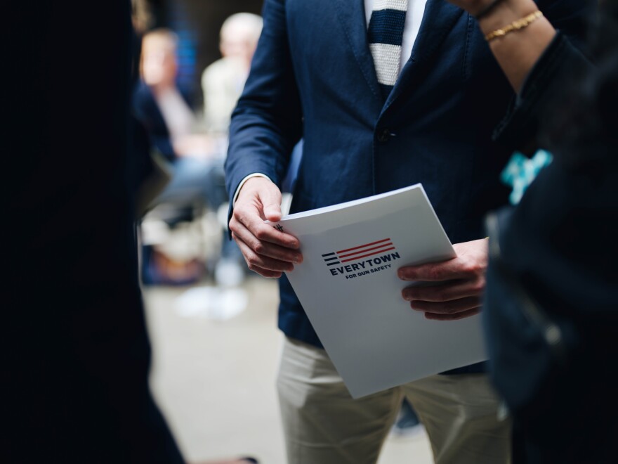 Matt McTighe holds an Everytown for Gun Safety folder at the DNC as he brings his message to the convention.