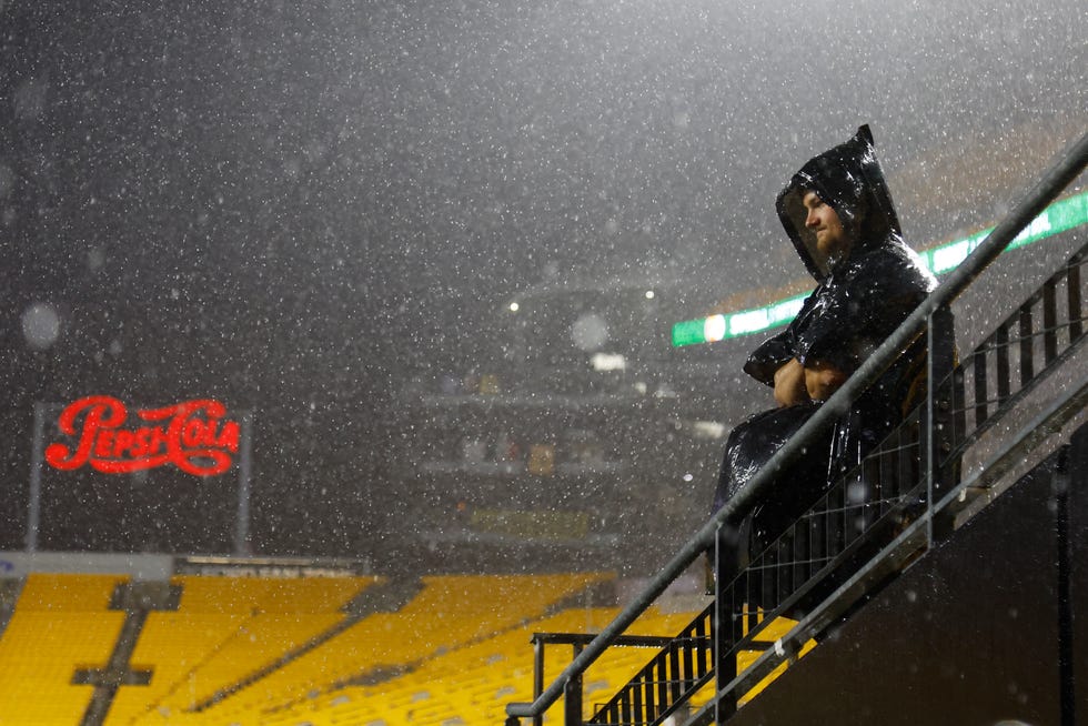 A fan stands in the rain during the weather delay of the game between the Pittsburgh Steelers and the Dallas Cowboys at Acrisure Stadium on October 06, 2024 in Pittsburgh, Pennsylvania.