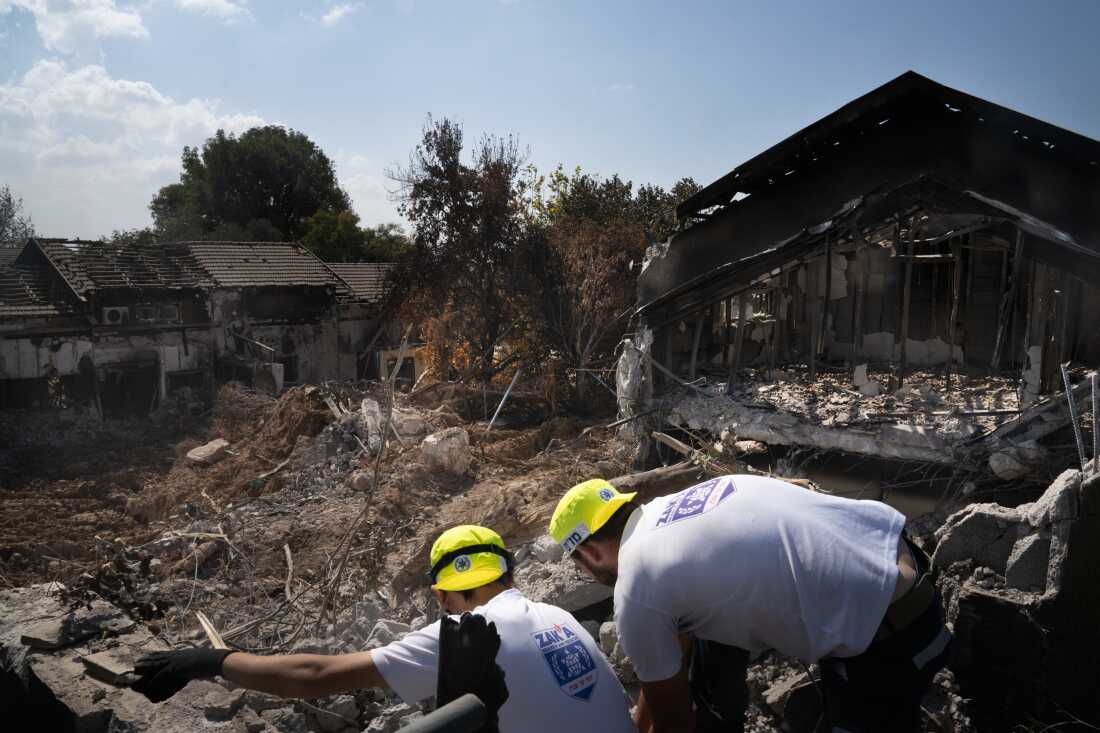 Men working with a search and recovery team from the organization Zaka look for human remains in Kibbutz Be'eri, in Israel on Oct. 20, 2023.