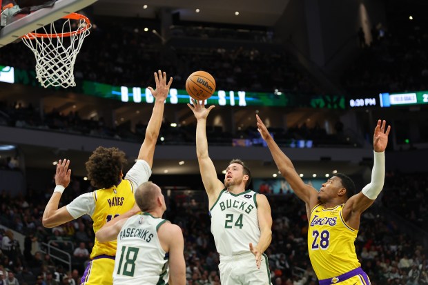 The Milwaukee Bucks’ Pat Connaughton, center, shoots in front of...