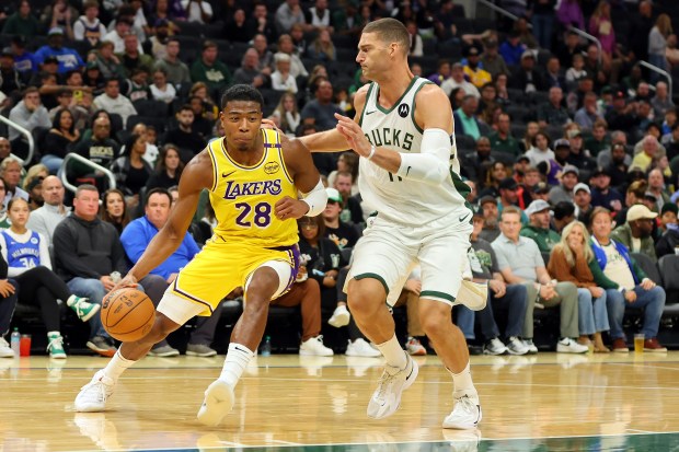 Lakers forward Rui Hachimura drives as Milwaukee Bucks center Brook...