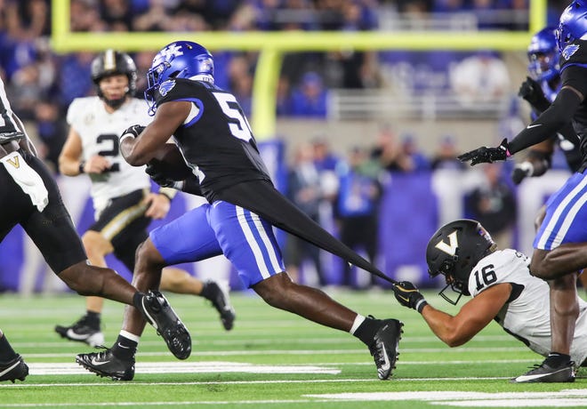 Linebacker D'Eryk Jackson (54) of the Kentucky Wildcats intercepts this pass in the first half as tight end Cole Spence (16) of the Vanderbilt Commodores tries to stop him with a grip on Jackson's shirt Saturday, Oct. 12, 2024 in Lexington, Ky.