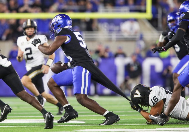 Linebacker D'Eryk Jackson (54) of the Kentucky Wildcats intercepts this pass in the first half as tight end Cole Spence (16) of the Vanderbilt Commodores tries to stop him with a grip on Jackson's shirt Saturday, Oct. 12, 2024 in Lexington, Ky.