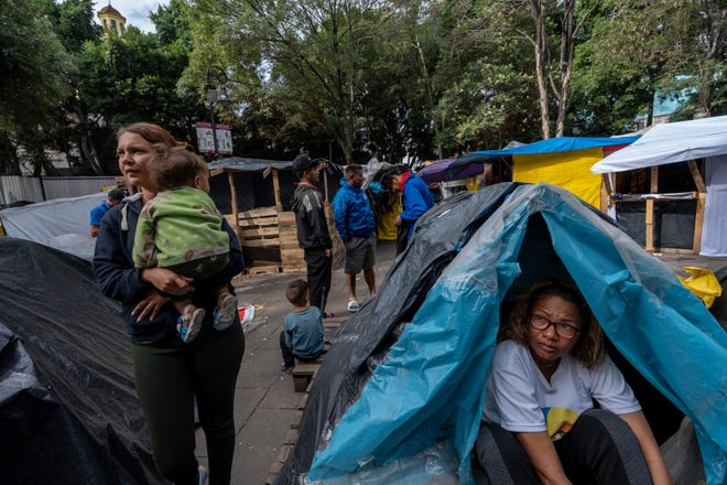 Mari Eduvid Sarmiento wakes up after sleeping in her tent in a public park in Mexico City where she has lived for months with her son and her husband waiting for an appointment to seek asylum in the U.S.