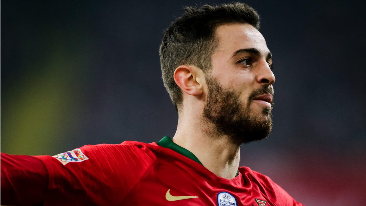 Bernardo Silva of Portugal, smiling, celebrating with arms outstretched.