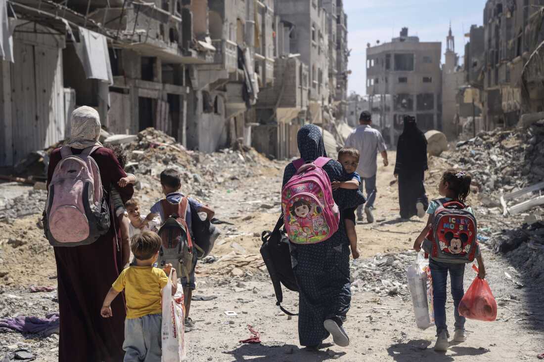 Palestinian women and their children walk though destruction in the wake of an Israeli air and ground offensive in Jabaliya, northern Gaza Strip, after Israeli forces withdrew from the area, on May 31.