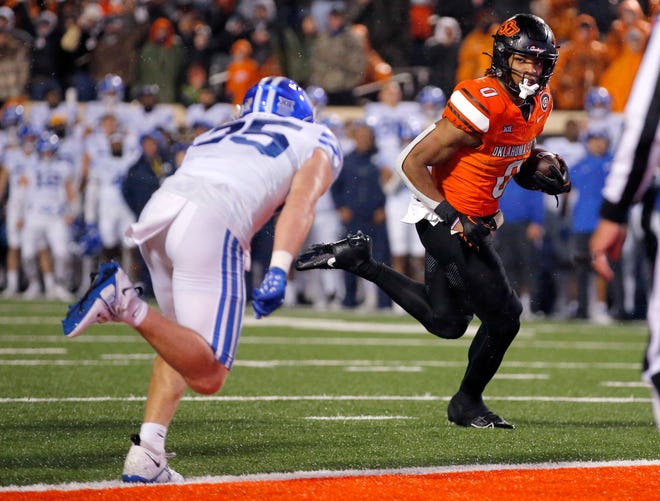 OSU running back Ollie Gordon II (0) scores a touchdown as BYU's Talan Alfrey (25) defends in the first overtime of the Cowboys' 40-34 double-overtime win on Nov. 25, 2023, at Boone Pickens Stadium in Stillwater.