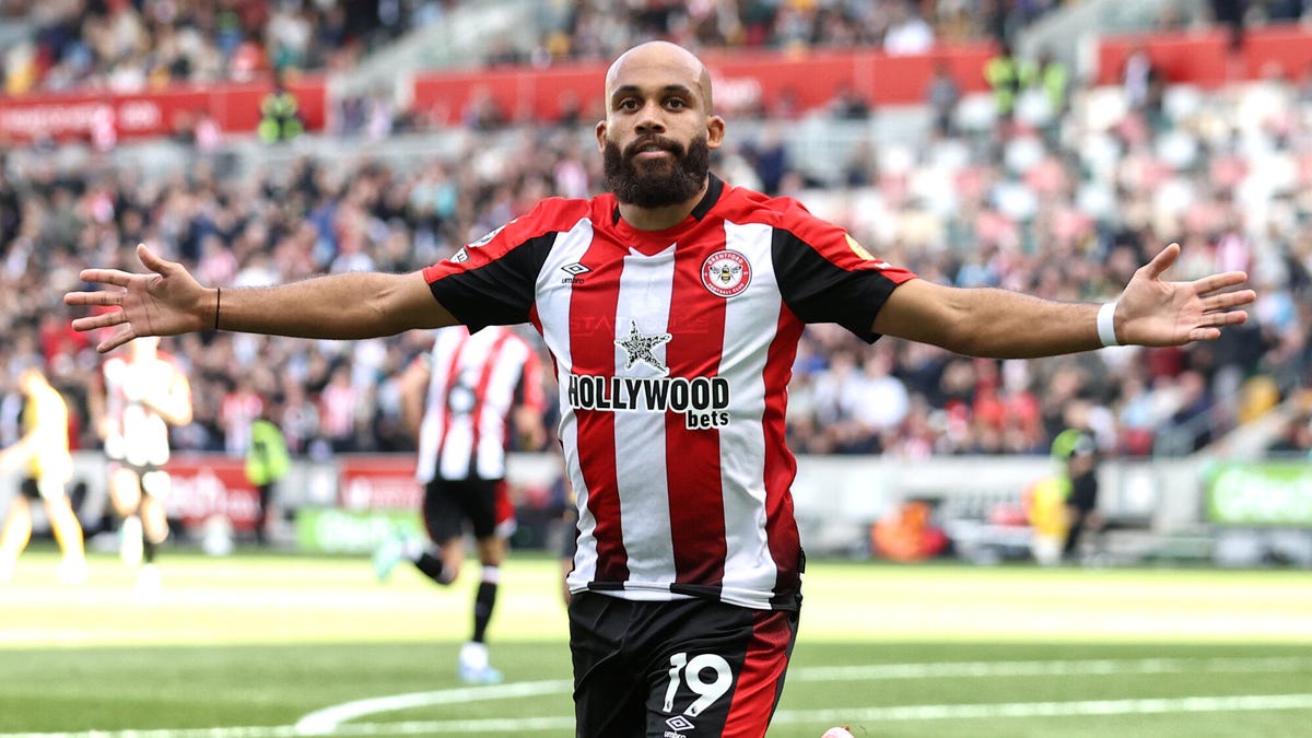 Brentford striker Bryan Mbeumo celebrating with both arms outstretched.