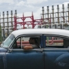 A person drives a classic American car past a floating generator that has not been producing electricity for days in Havana, Cuba, Friday, Oct. 18, 2024.