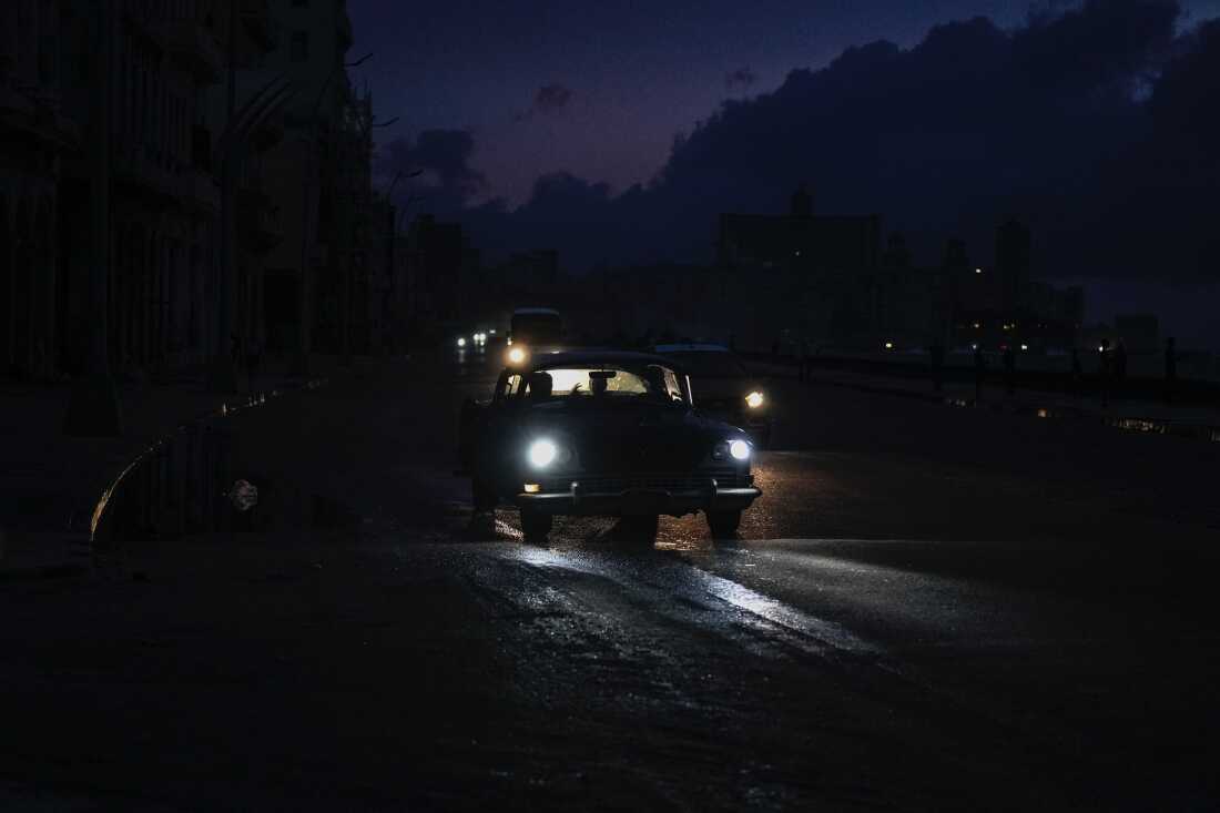 Vehicles make their way along the Malecon during a massive blackout after a major power plant failed in Havana on Friday.