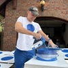 Jason Brown spray-paints a blue dot sign in his driveway in Omaha, Neb. on Oct. 9, 2024.