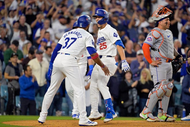 Los Angeles Dodgers shortstop Tommy Edman (25) celebrates with outfielder Teoscar Hernandez (37) after scoring on a two run home run in the third inning against the New York Mets during Game 6 of the NLCS for the 2024 MLB playoffs at Dodger Stadium.