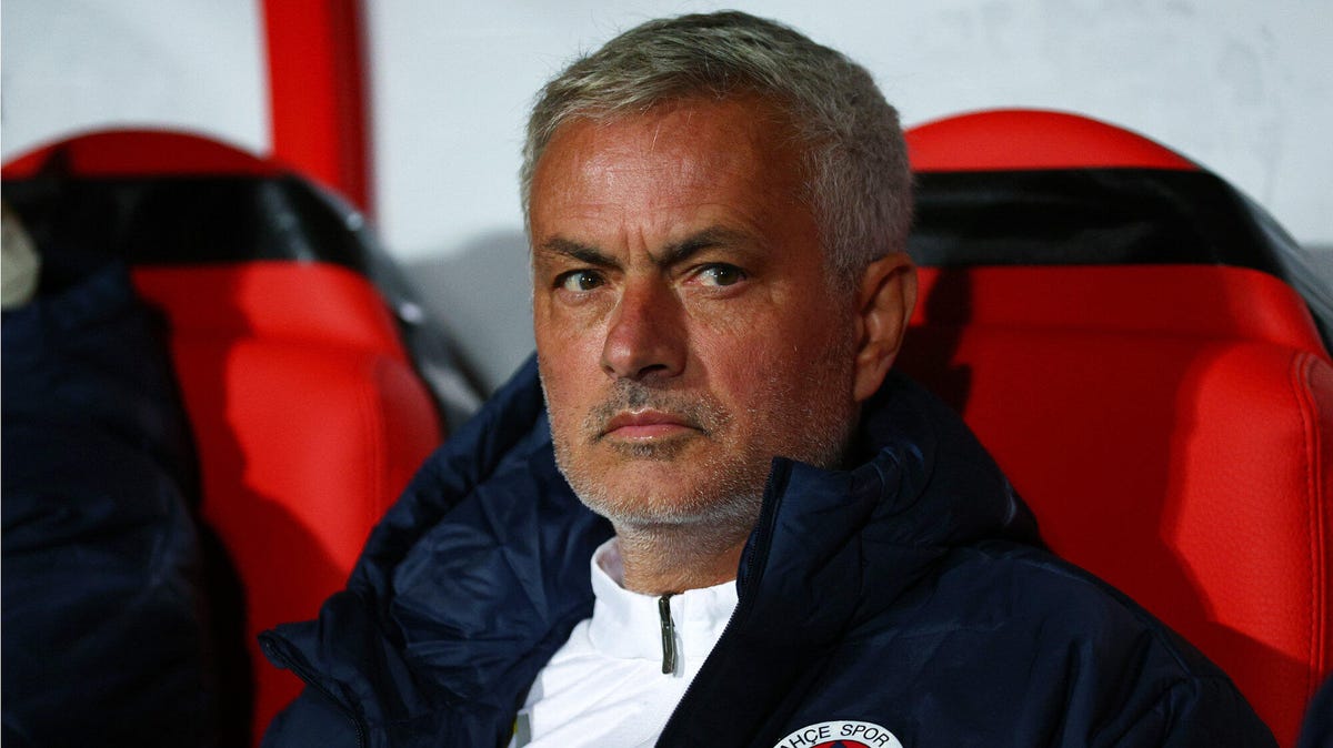 Jose Mourinho, Head Coach of Fenerbahce SK sitting in a dugout, looking over to his right.