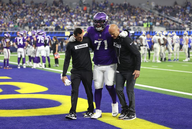 Vikings tackle Christian Darrisaw is helped off the field after he was injured late in the second quarter.