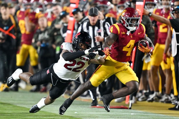 USC running back Woody Marks,, right, is pushed out of...