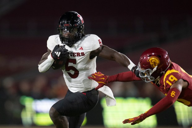 Rutgers running back Kyle Monangai, left, runs with the ball...