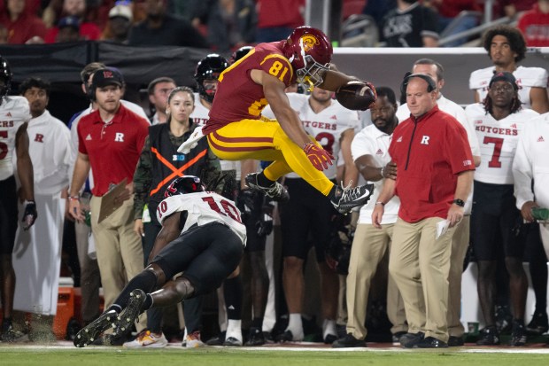 USC wide receiver Kyle Ford leaps over Rutgers defensive back...