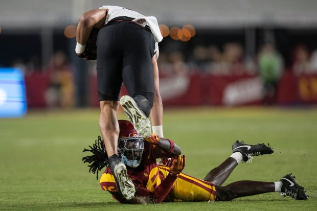 USC cornerback Prophet Brown, bottom, tackles Rutgers tight end Mike...