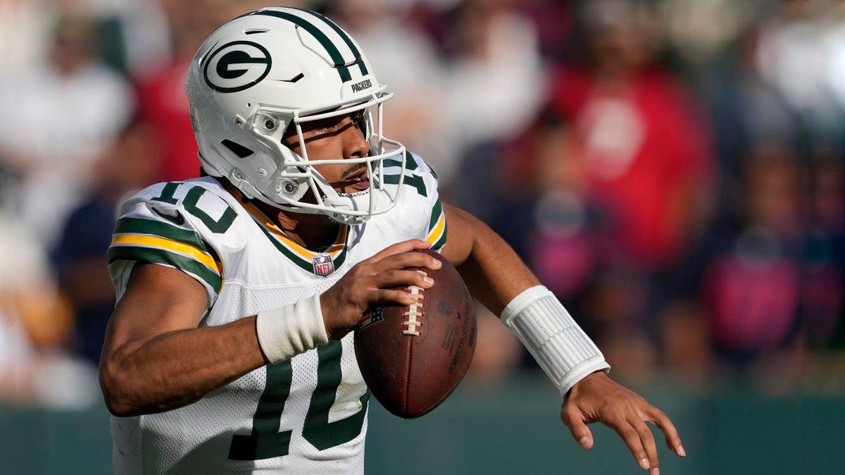 Jordan Love of the Green Bay Packers holding a ball with his right hand.