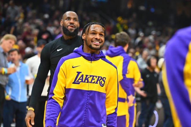 Los Angeles Lakers players Bronny James (9) and LeBron James (23) warm up before a game against the Cleveland Cavaliers on Wednesday n Cleveland.