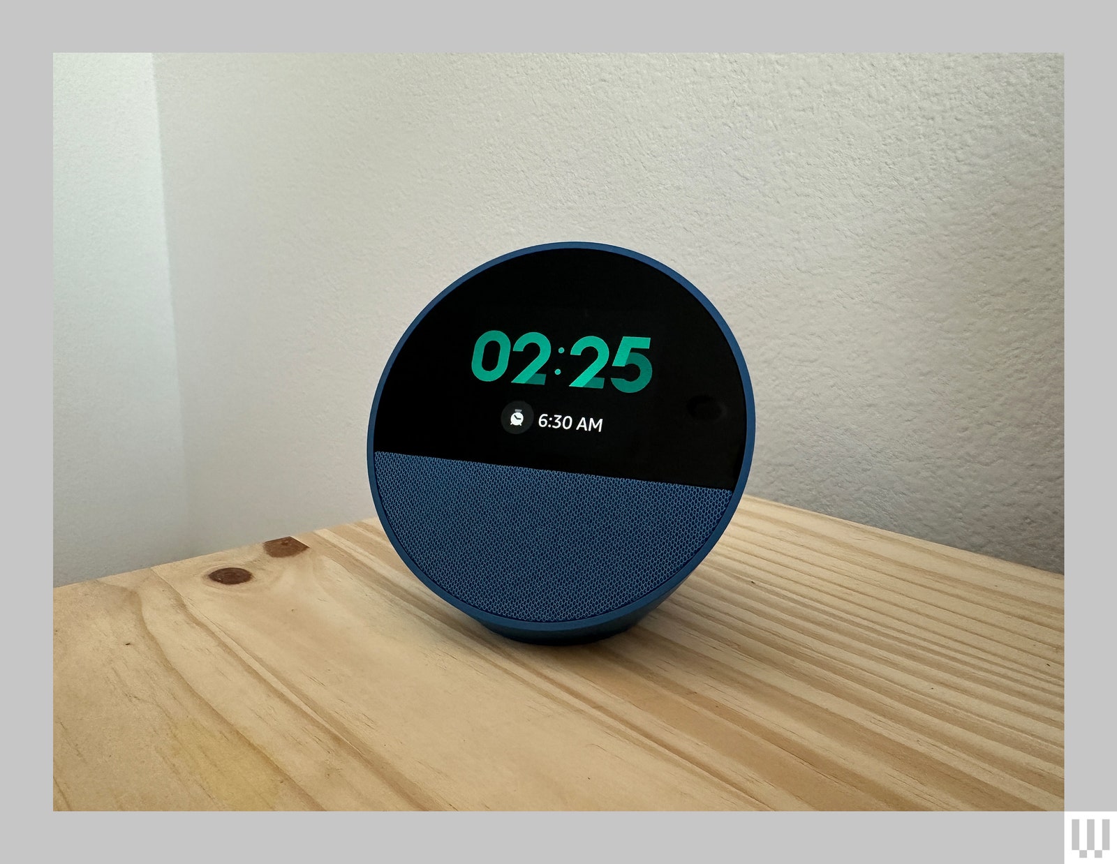 Semisphere Echo Spot device with a screen on the front displaying the current time as well as the time the alarm is set for.