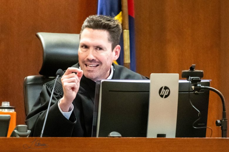 A judge gestures with his hand as he sentences Tina Peters to incarceration