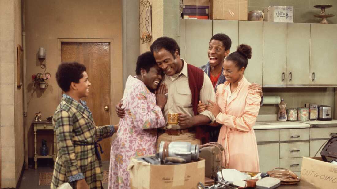 Ralph Carter, Esther Rolle, John Amos, Jimmie Walker, and BernNadette Stanis gather in the kitchen during a scene from Good Times in 1975.