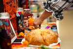 Yamely Chavez Kennedy makes sure the ofrenda is just right at Colima Market in Bend, Ore. on Oct. 30, 2024.